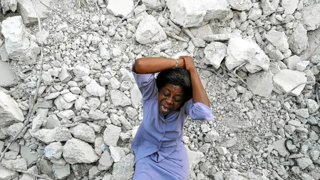 Una mujer haitiana muestra su desesperación entre los escombros de un edificio derruido, en Puerto Príncipe
