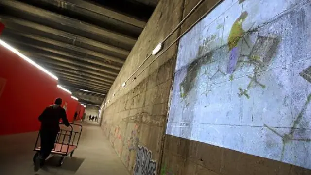 El pasadizo central, con grafitis e imágenes de proyectores, por donde antes discurrían las vías.