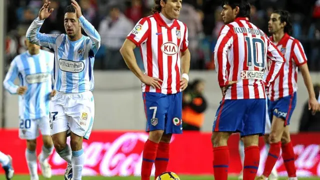 Diego Forlán y el 'Kun' Agüero, resignados, se disponen a sacar de centro tras el 0-2 del Málaga.