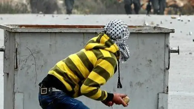 Un palestino se prepara para tirar piedras a la Policía israelí