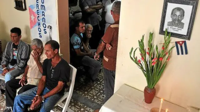 Opositores cubanos, ayer, en la casa de la líder de las Damas de Blanco junto a una foto de Zapata