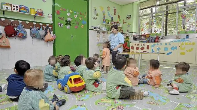 Un grupo de niños atienden a su profesora en una guardería de Zaragoza.
