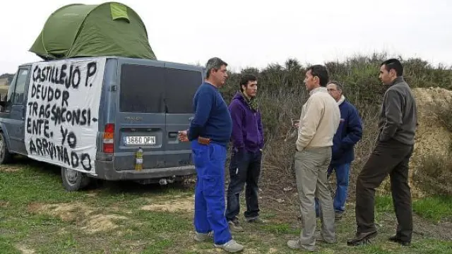 Dos representantes de Tragsa (derecha) conversan con tres de los afectados sobre su situación.