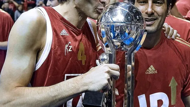 Matías Lescano, abrazado a Paolo Quinteros, besa el trofeo de campeones