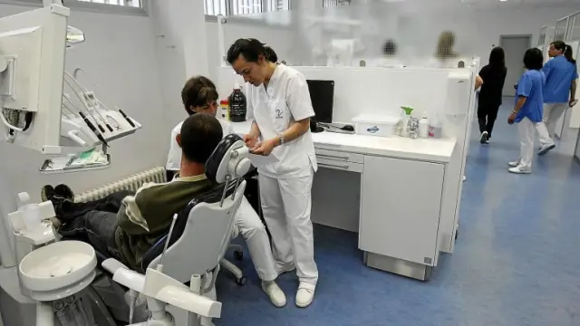 Dos chicas atienden a uno de los primeros clientes de la clínica de Odontología, Antonio Jesús López Caballero.