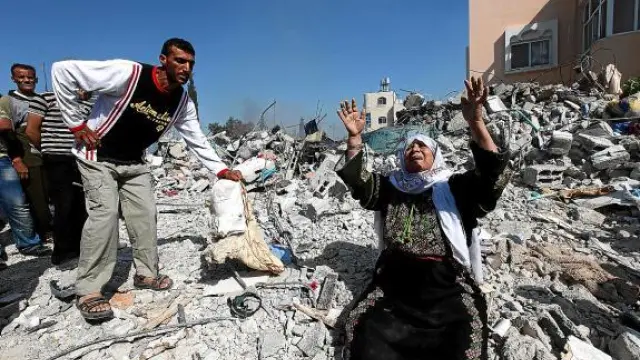 La madre del miliciano de Hamás muerto llora sobre las ruinas de la casa en la que vivía, ayer.
