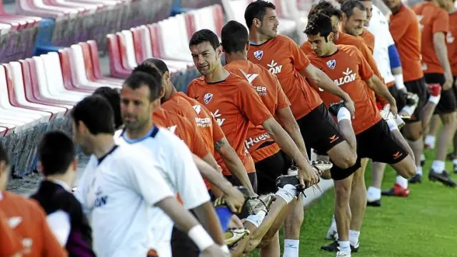Los futbolistas del Huesca realizan estiramientos durante un entrenamiento en el estadio de El Alcoraz.