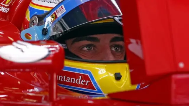 Fernando Alonso observa desde su Ferrari los tiempos de la tercera ronda de calificación.