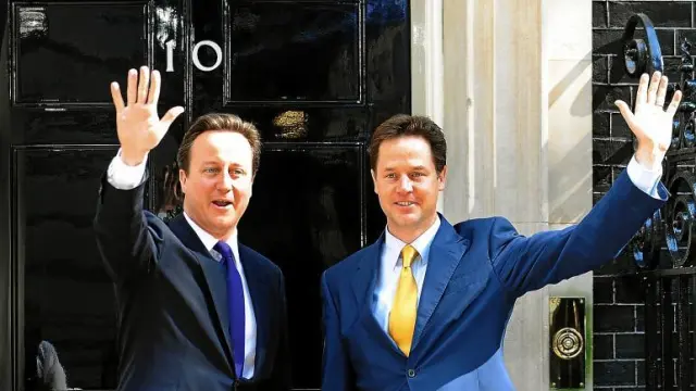 Cameron, a la izquierda, y Clegg saludan juntos desde el 10 de Downing Street, residencia oficial del primer ministro británico.