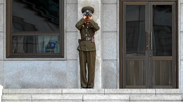 Un guardia norcoreano mira en dirección al sur a través de sus prismáticos, en la localidad fronteriza de Panmunjeom, ayer.