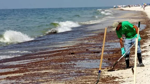 Un voluntario limpia las mancha de crudo en una playa de Gulf Shores, Alabama, ayer.