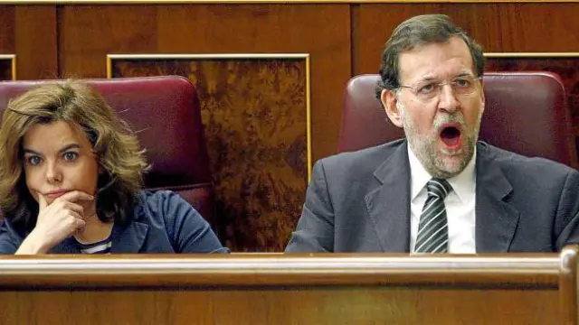 El líder del PP, Mariano Rajoy, bosteza junto a la portavoz popular, Soraya Sáenz de Santamaría.