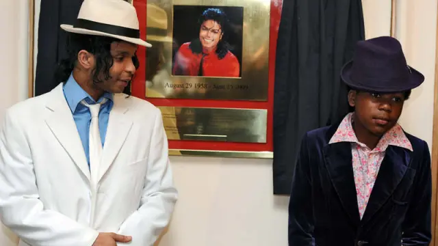 Dos actores del musical 'Thriller' junto a una placa que conmemora el aniversario de la muerte de Michael