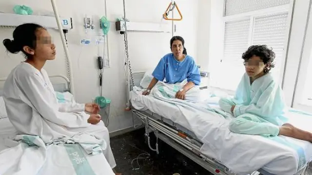 Zulica, en el centro, con dos hijas, en la habitación el hospital donde se recuperan de la intoxicación.