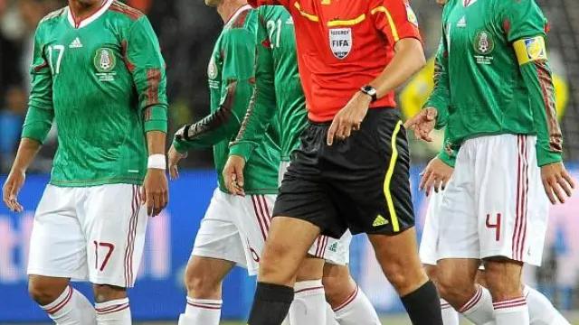 Roberto Rosetti, rodeado de jugadores mexicanos, tras el polémico gol en fuera de juego de Tévez.