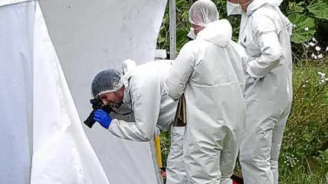 Investigadores forenses analizan el sitio donde murió Moat.