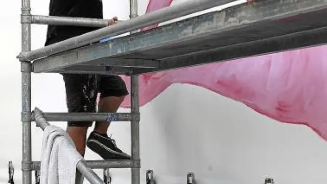 El pintor Leto colorea una de las lonas del camión.