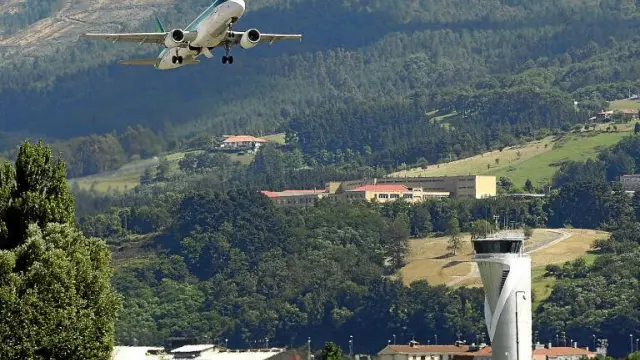Un avión despega ante la torre de control del aeropuerto de Bilbao.