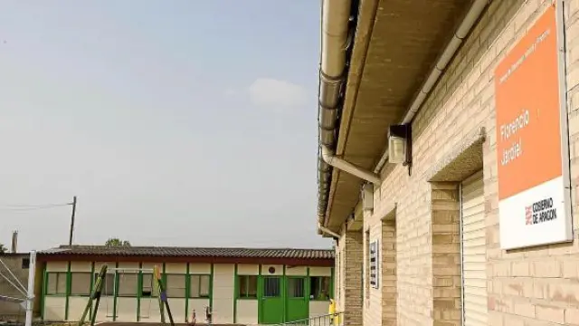 Los módulos (al fondo) se encuentran pegados al colegio, construido de ladrillo.