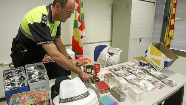 El oficial José Mª Salvador, con una pequeña muestra de los objetos incautados a los 'manteros'.