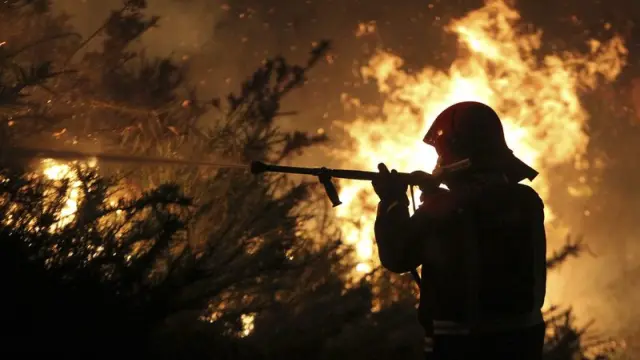Un bombero trabaja en la zona afectada por el incendio de Pontevedra.