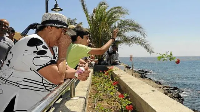 Familiares de fallecidos en el accidente lanzan flores al mar, ayer en Ojos de Garza (Gran Canaria).