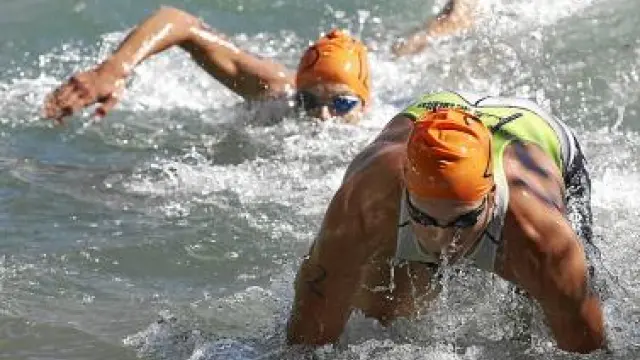 Dos participantes nadan en la primera prueba del triatlón.