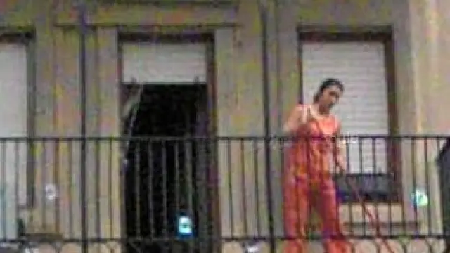 Limpiando en la plaza de San Pedro Nolasco, en Zaragoza. Una mujer barre un balcón. Aun con el rostro difuminado, su silueta permite reconocerla.
