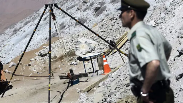 Un policía custodia un ducto que conduce hasta los mineros atrapados
