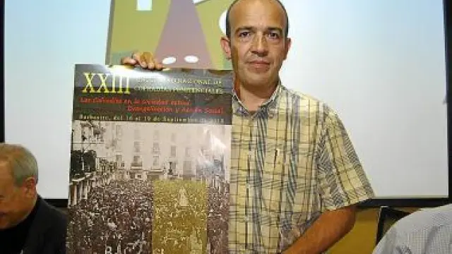 Rafael Torres, coordinador del encuentro, junto al cartel.