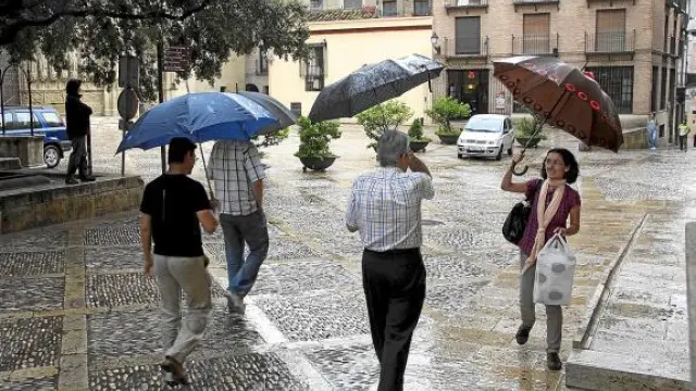Paraguas en Huesca. Los oscenses sacaron a la calle sus paraguas para guarecerse de las precipitaciones, que fueron más intensas de madrugada. Pese a ello, los bomberos no hicieron ni una sola salida.