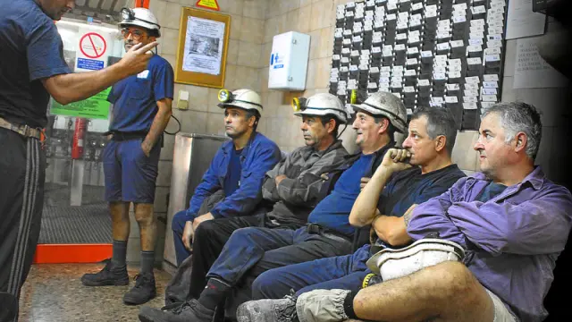 Un grupo de trabajadores de la mina de Samca en la localidad de Ariño muestran rostros de preocupación durante un cambio de turno en la jornada de ayer.