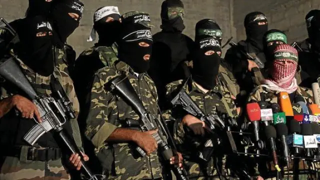 El portavoz de Hamás (d), Abú Obaida, rodeado de militantes del movimiento, el jueves en Gaza.