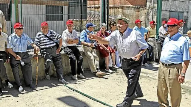 Un grupo de pensionistas juegan a la petanca.