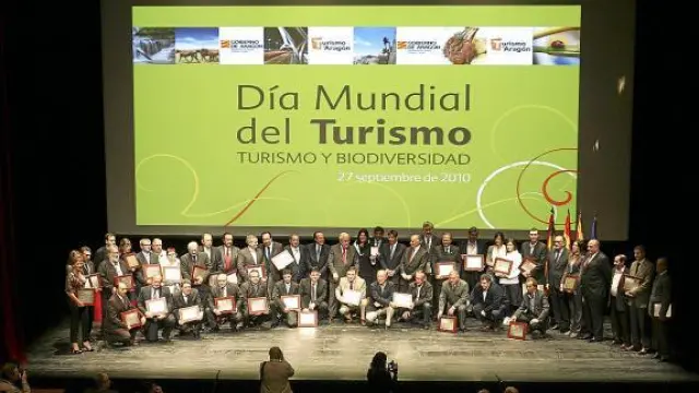 Los 33 premiados en el Día del Turismo, junto a representantes políticos, ayer en Huesca.