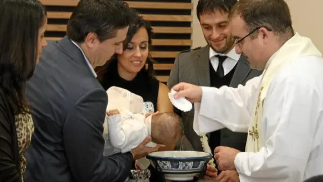 Jorge Ezquerro, con sus padres, padrinos -Cristina y Óscar- y el párroco Santiago Aparicio.