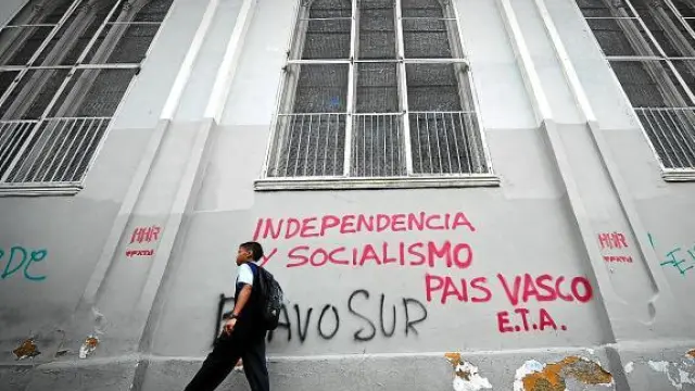 Un chico pasea ante un edificio con pintadas a favor de ETA, ayer en Caracas.