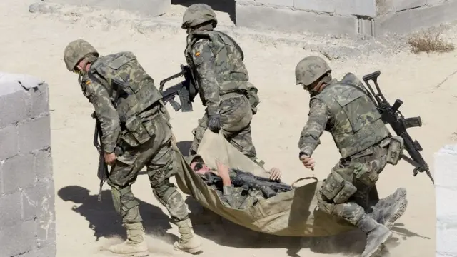 Unos soldados trasladan a un supuesto herido durante los ejercicios de adiestramiento