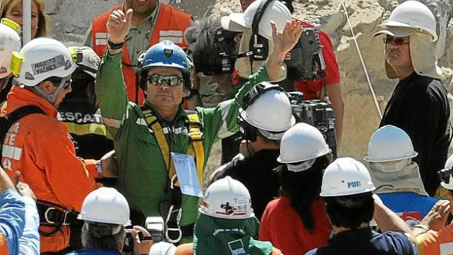 El minero Pablo Rojas levanta los brazos en señal de victoria después de ser rescatado de la mina.