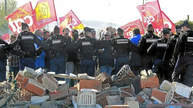 Policías franceses se enfrentan a los trabajadores que bloquean el acceso a la refineria de Frontignan-la-Peyrade, ayer.