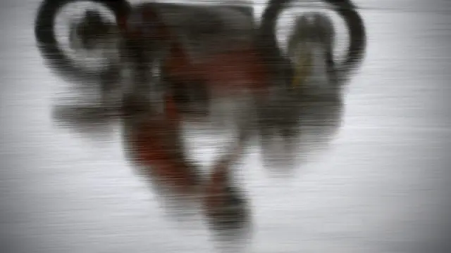 La silueta de un corredor de 125 se refleja en el asfalto mojado