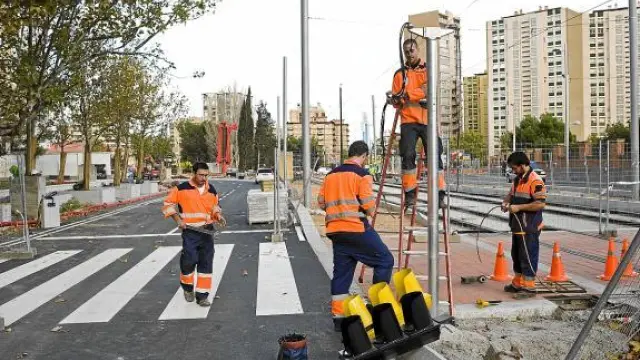 Los operarios preparan la señalización de la calzada de Vía Ibérica, recientemente renovada.
