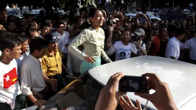 Aung San Suu Kyi saluda a sus seguidores a la salida de la sede de su partido, después de terminar su primer día de trabajo