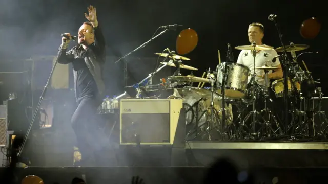 Bono, cantente de U2, con Larry Mullen tras él, durante una actuación en 2009