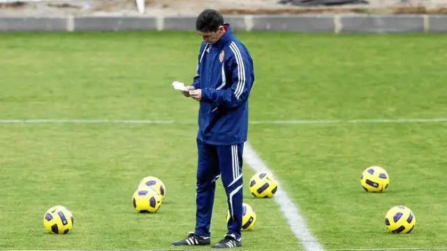 José Aurelio Gay revisa unas notas en su agenda, durante el entrenamiento que dirigió ayer en la Ciudad Deportiva.