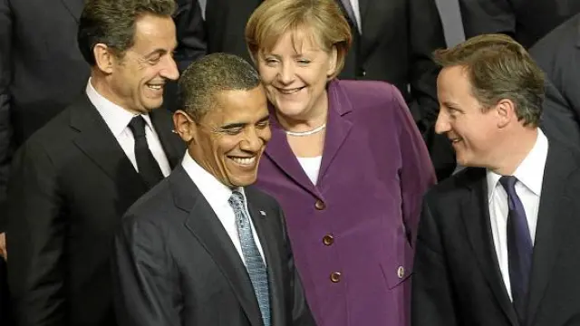 Sarkozy, Obama, Merkel y Cameron sonríen durante la foto de grupo de la cumbre de la OTAN.