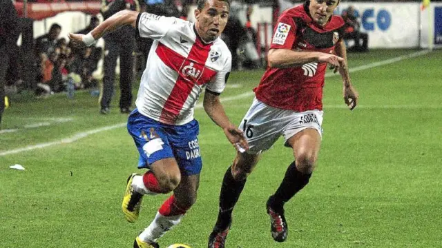 Gilvan Gomes, uno de los futbolistas más destacados del Huesca en el partido de ayer, trata de marcharse de un rival.