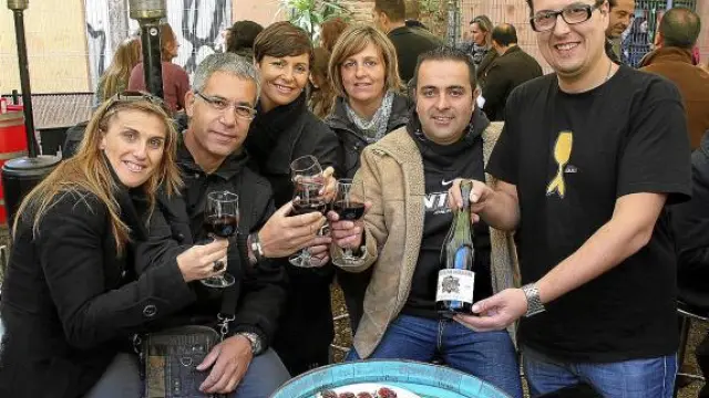 Clientes y el propietario de Bodegas Almau, brindando ayer con vino 'Beaujolais nouveau'.