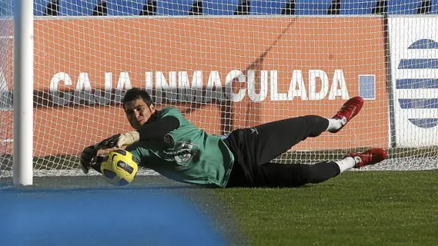 Andrés se estira para atajar un balón durante el entrenamiento que el Huesca hizo, ayer, sobre el césped de El Alcoraz.