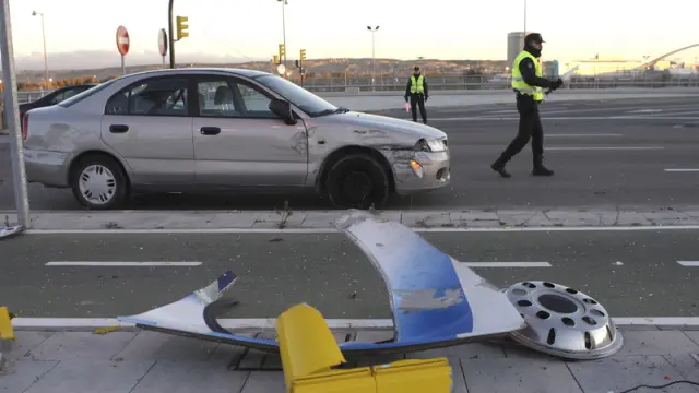 El coche implicado en el accidente, junto a varios objetos de la calzada destrozados